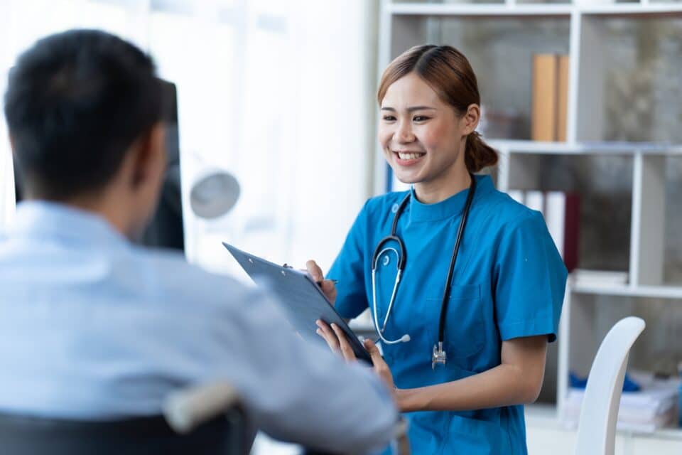 Doctor and patient sitting and talking at medical examination at hospital office